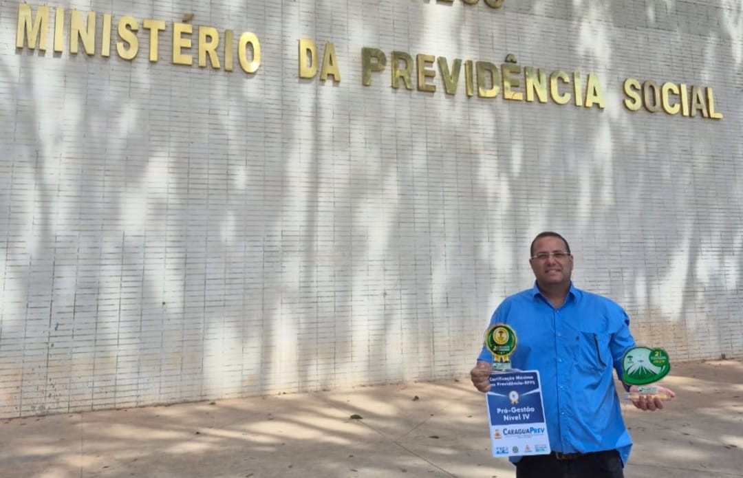 #PraTodosVerem: Presidente do CaraguaPrev, Pedro Ivo de Sousa Tau, segura os troféus de 3º colocado no 2º Prêmio Selo Gestor Nacional e no 2º Prêmio Nacional de Investimentos da Associação Nacional de Entidades de Previdência de Estados e Municípios (Aneprem) realizado julho na frente do Ministério da Previdência Social, em Brasília (DF) (Foto: Divulgação/PMC) 